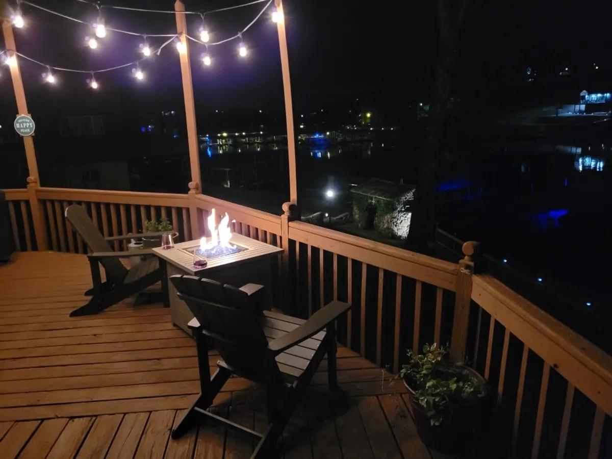 An inviting fire pit area on a wooden deck, surrounded by string lights and comfortable seating. This space is designed for evening relaxation, s’mores, stargazing, and creating special moments together as a family.